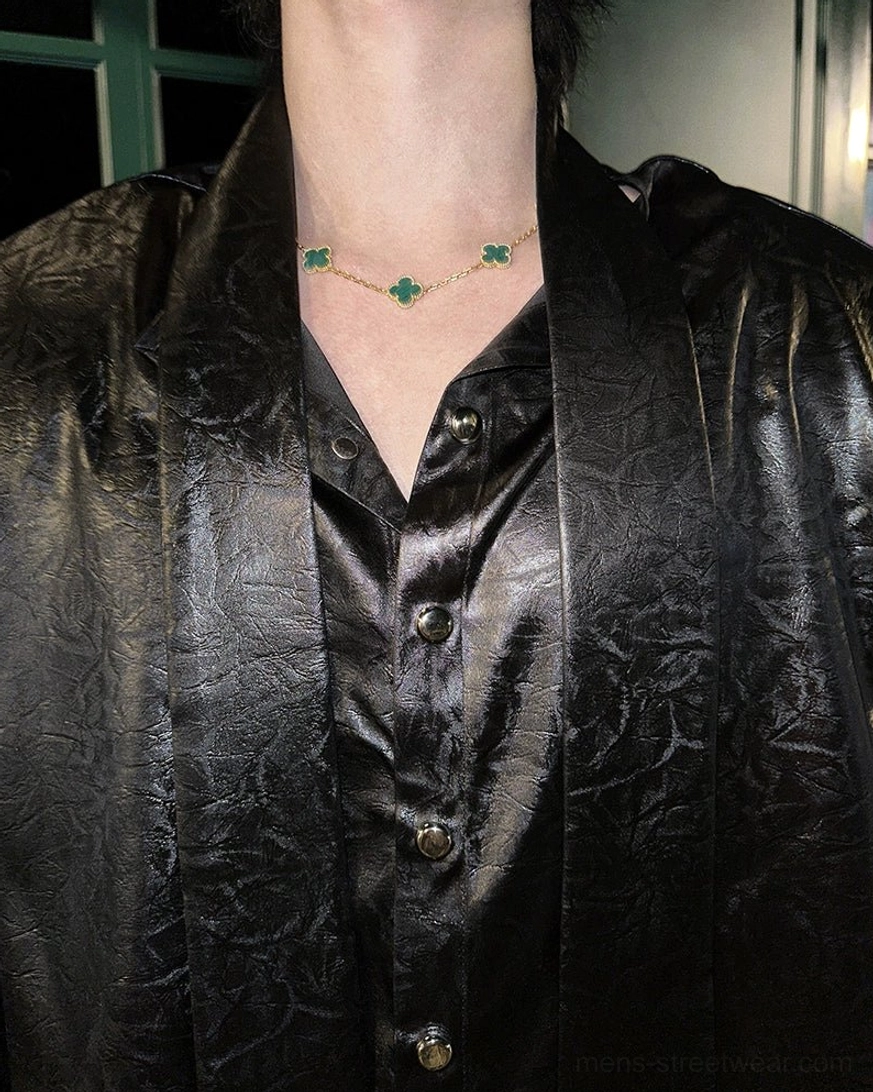 Close-up of button-front placket and matching tie detail on a black glossy streetwear shirt