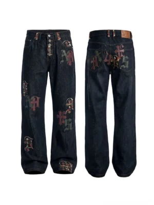 Front and back flat lay of black Gothic letter appliqué straight-leg denim jeans with cross patches and multi-button fly