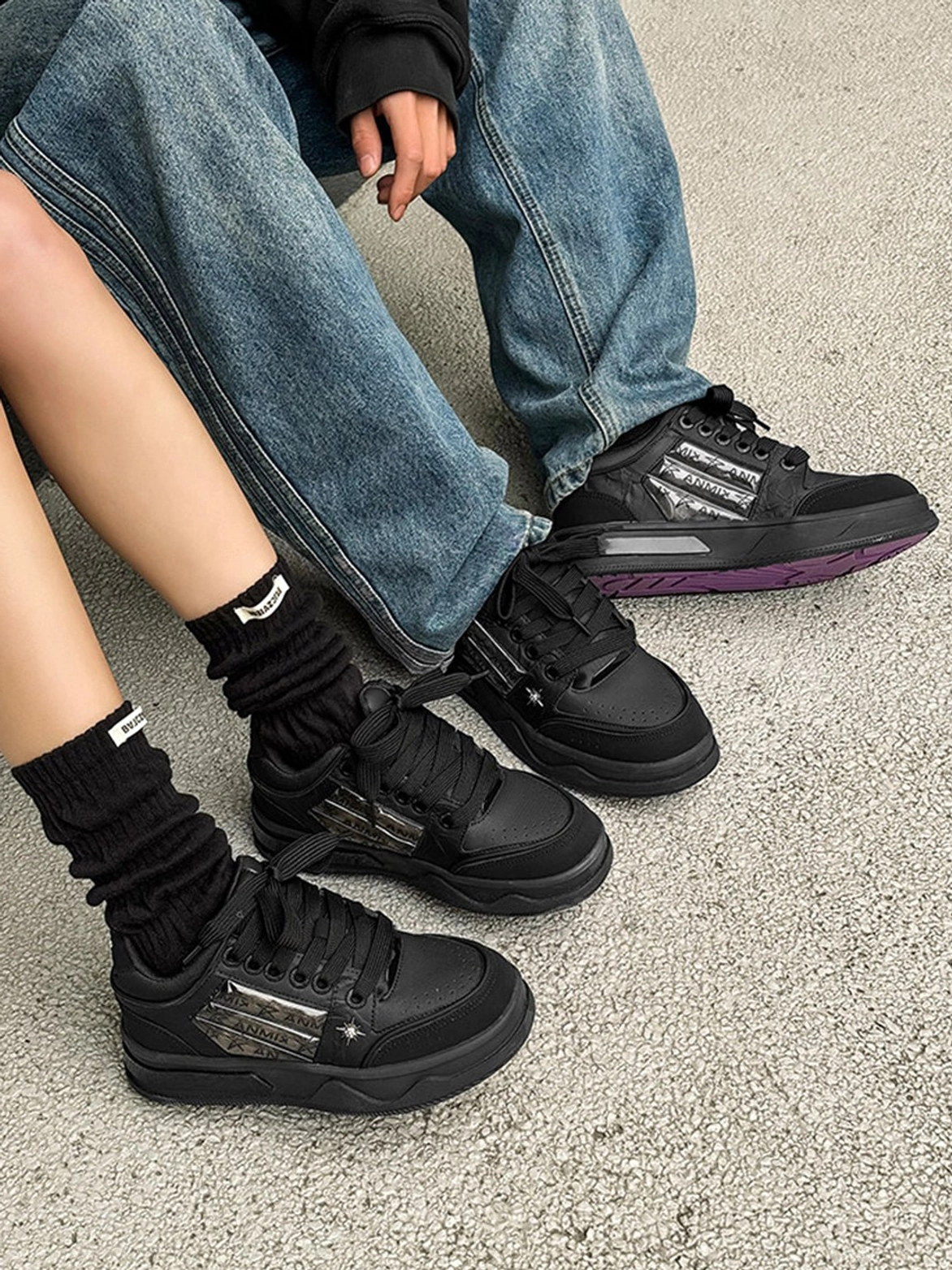 Black gothic platform sneakers with star detailing, silver decorative stripes, and skate-inspired low-top construction