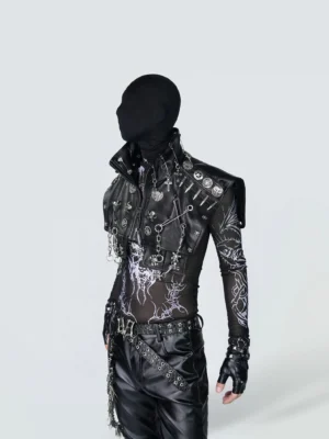 Black gothic punk harness vest with layered chains, studded hardware, and cropped faux leather silhouette styled over a sheer streetwear outfit