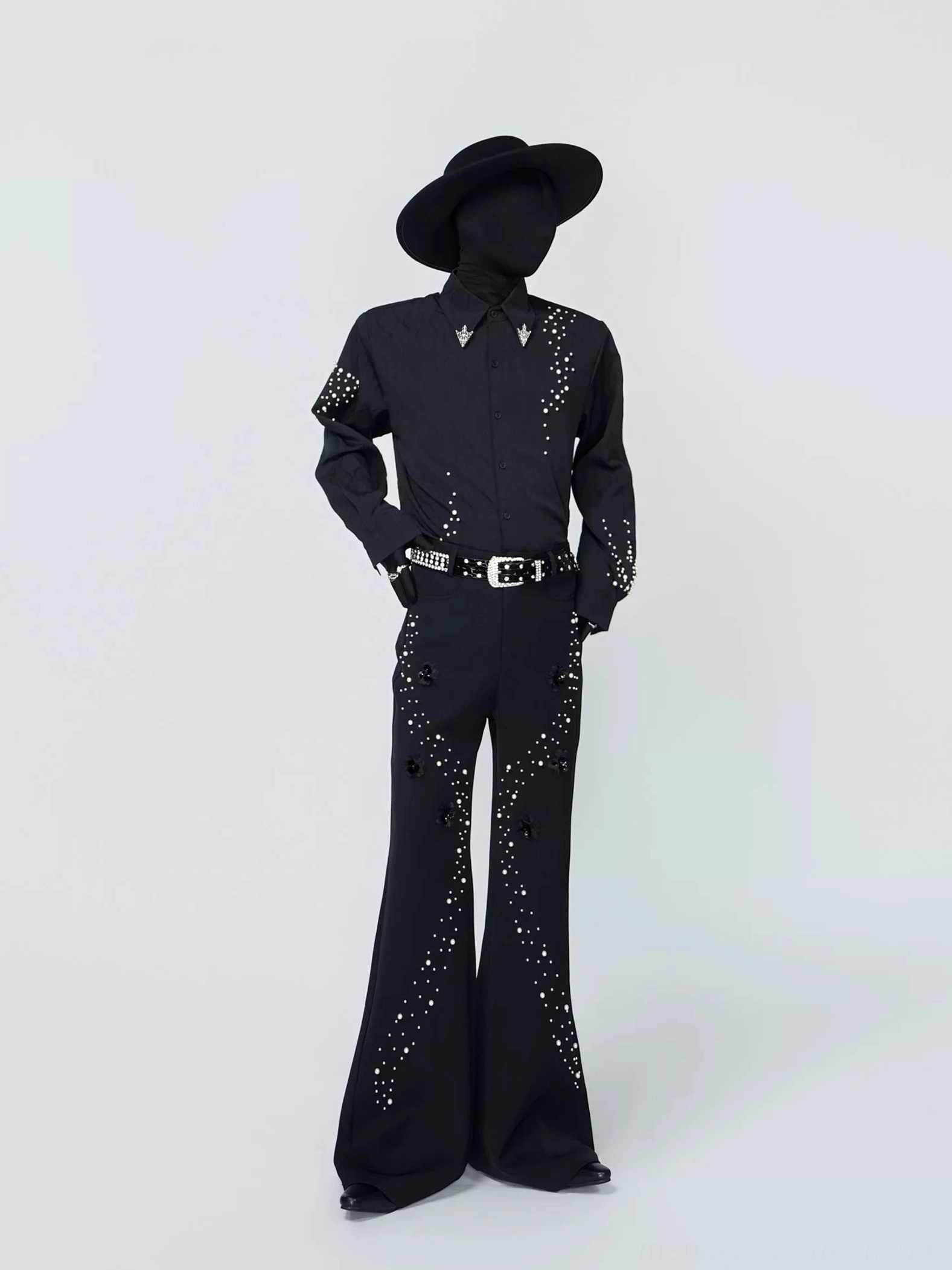 Side three-quarter view of a black gothic streetwear button-down shirt featuring scattered constellation studs on the sleeves and sharp metal collar tips