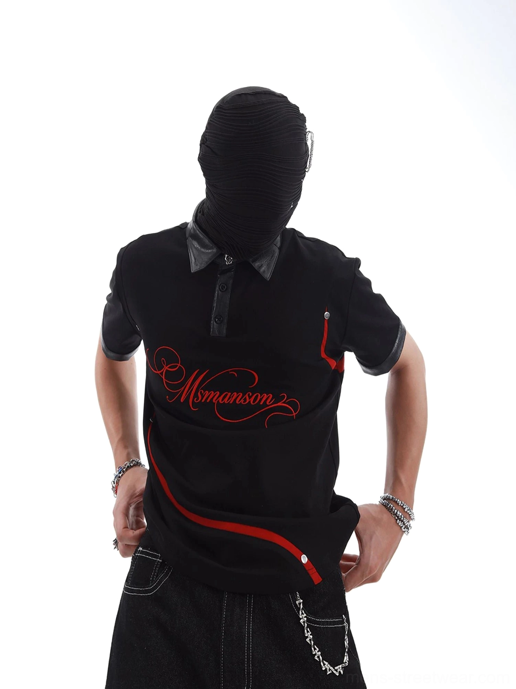 Three-quarter view of black graphic streetwear polo with faux leather collar zip chest pocket red arc stripe and silver hardware