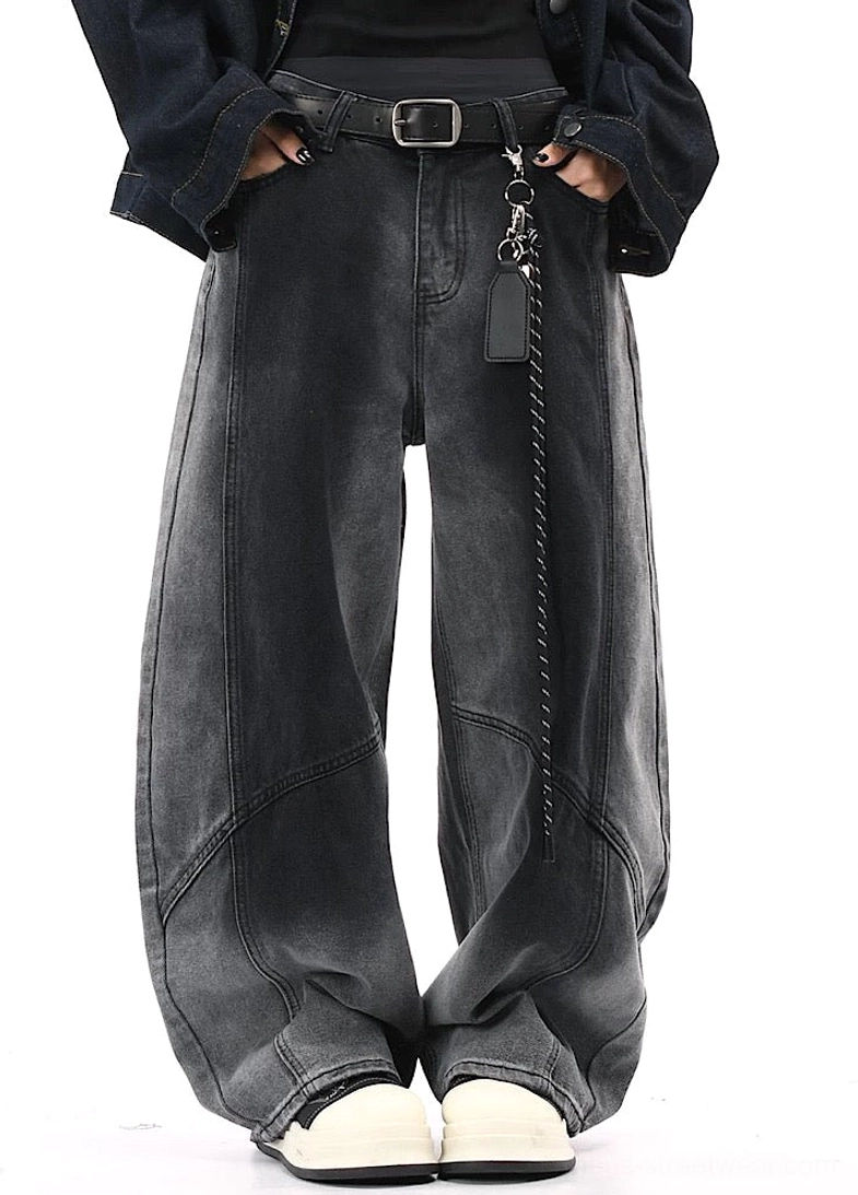 Front full-body view of black to gray faded wide-leg pants styled with a black denim jacket and platform shoes