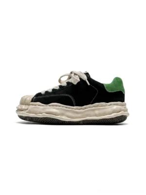 Black and green shell-toe platform sneakers with textured suede upper, cream chunky sole, and green heel tab shown in a three-quarter product view