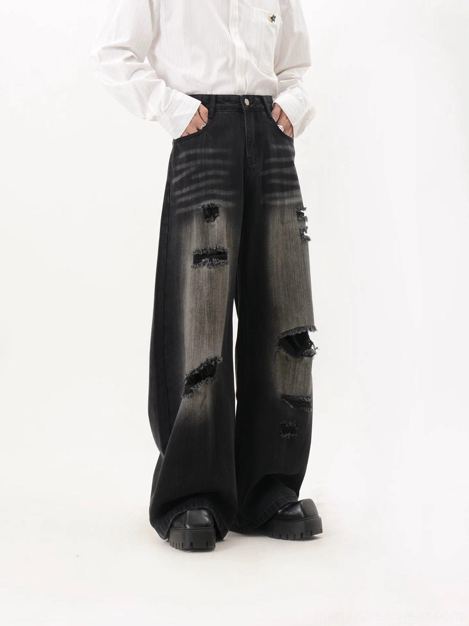 Full front view of black grey gradient heavily distressed wide leg jeans with asymmetric ripped details and floor-grazing silhouette