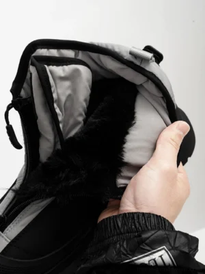 Close-up view of black faux fur lining and grey quilted interior inside a mid-calf winter snow boot with front zipper