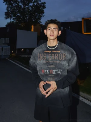 Black grey washed vintage university graphic sweatshirt with retro collegiate lettering and relaxed long sleeve streetwear fit