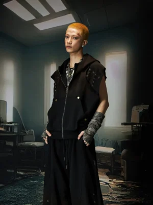 Black grommet hooded vest in three-quarter front view with sleeveless boxy fit and full zip closure