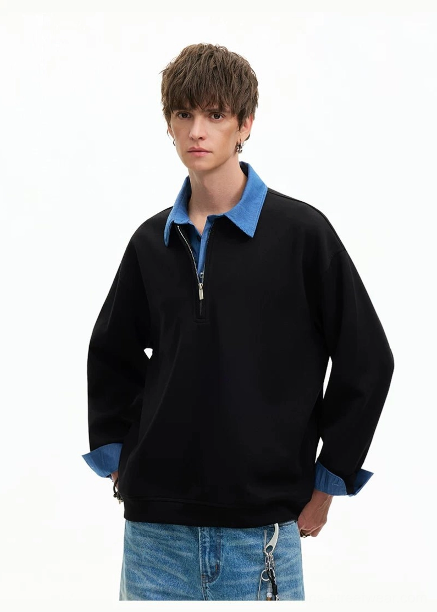 Three-quarter front view of black half-zip streetwear sweatshirt with blue denim-look trim and relaxed fit