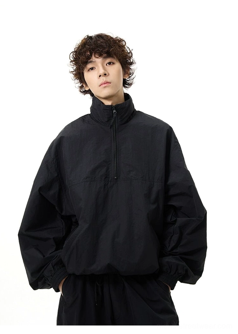 Front view of a loose black half-zip windbreaker with stand collar, long sleeves, and oversized Seoul streetwear fit