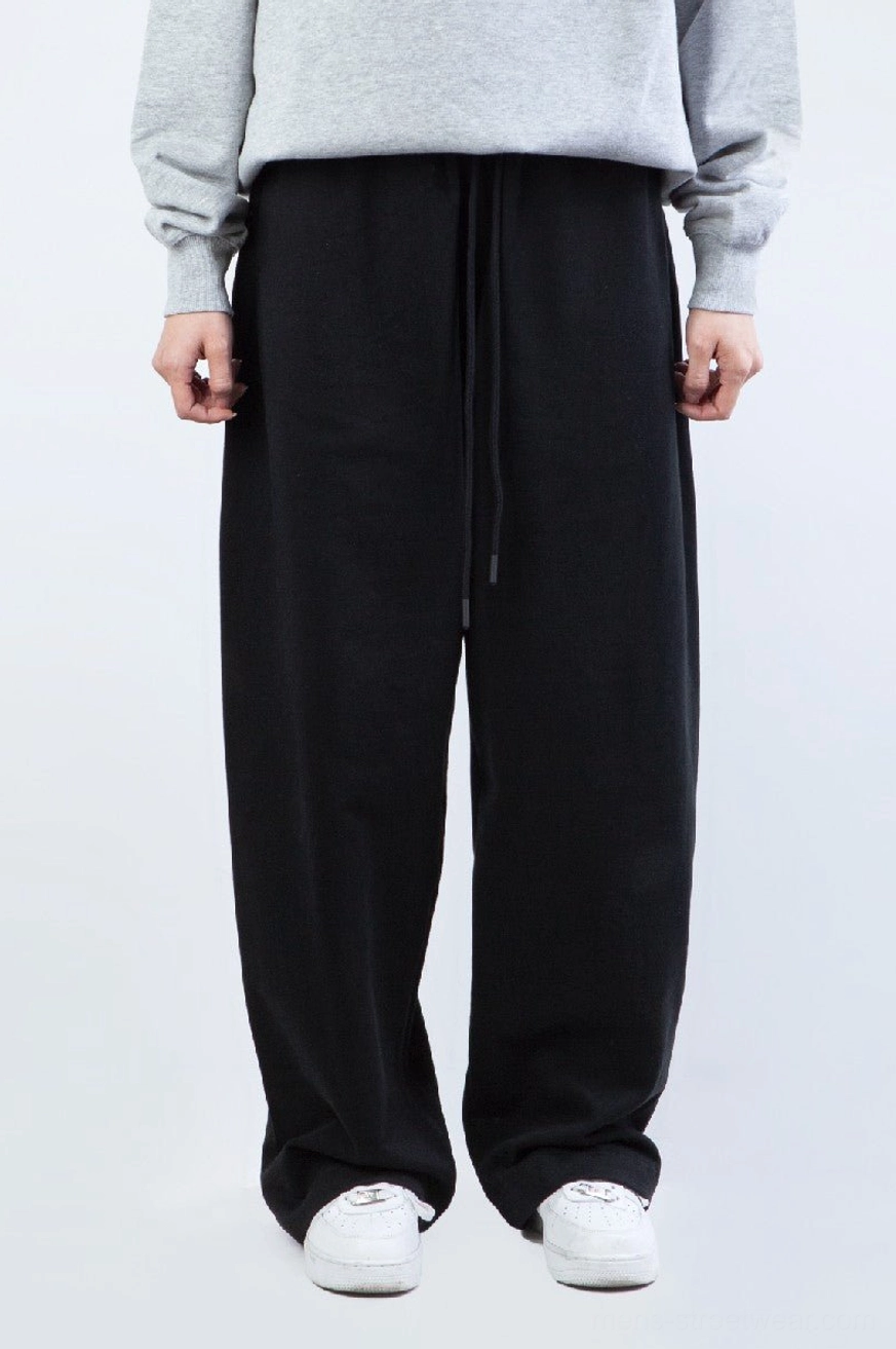 Black heavyweight straight leg streetwear sweatpants worn with gray sweatshirt and white sneakers front outfit view