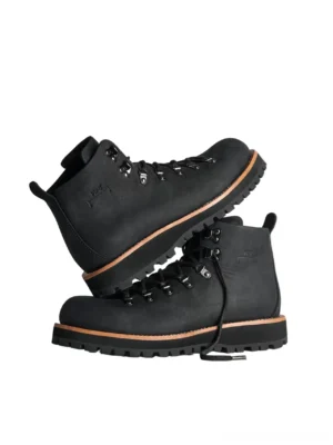 Black heritage leather hiking boots stacked in studio with silver lace hardware tan welt trim and deep traction lug outsole