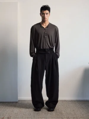 Black high-rise pleated belted wide-leg tailored trousers shown in a full-body front studio streetwear outfit
