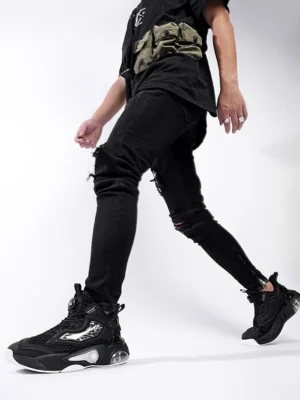 Black high-top air-cushion sneakers styled with black streetwear clothing in a low-angle urban fashion view