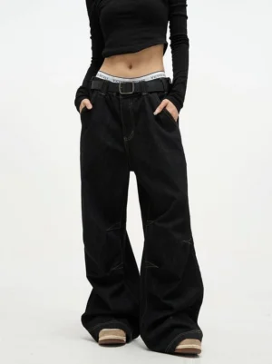 Front view of black high waist baggy wide leg denim jeans with contrast stitching styled with a cropped black top