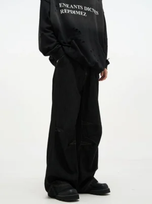 Rear angled view of black baggy wide leg denim jeans showing panel seams and relaxed streetwear fit