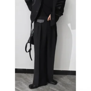 Front view of black pleated wide-leg trousers with high waist tailored silhouette styled with blazer and leather shoes