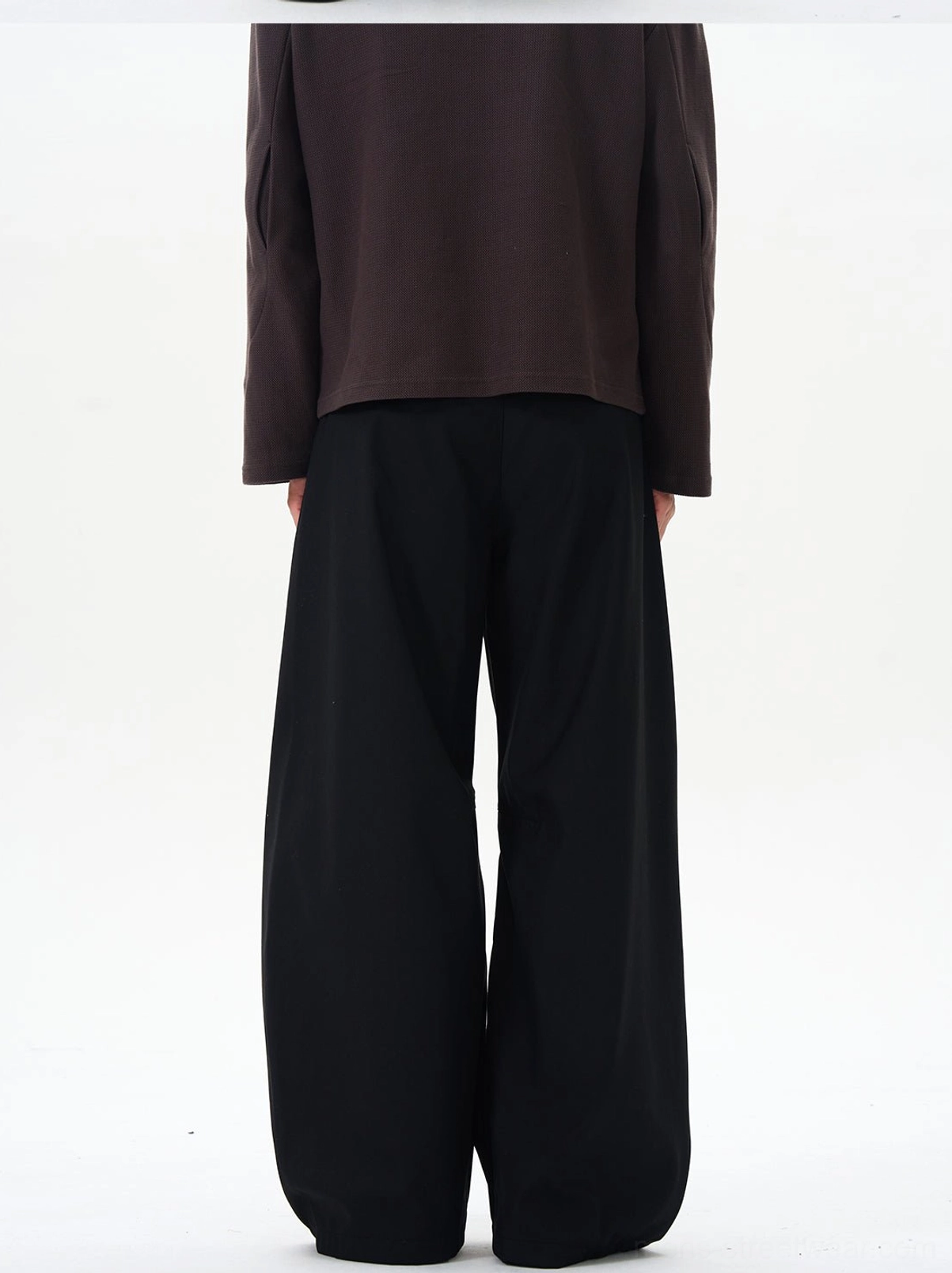 Back view of black high-waisted palazzo pants showing the neat waistband and discreet back pocket construction