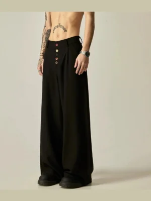 Black high-waisted wide-leg streetwear trousers shown from the front with a contrast button placket, smooth drapey suiting fabric and ultra-wide floor-length silhouette