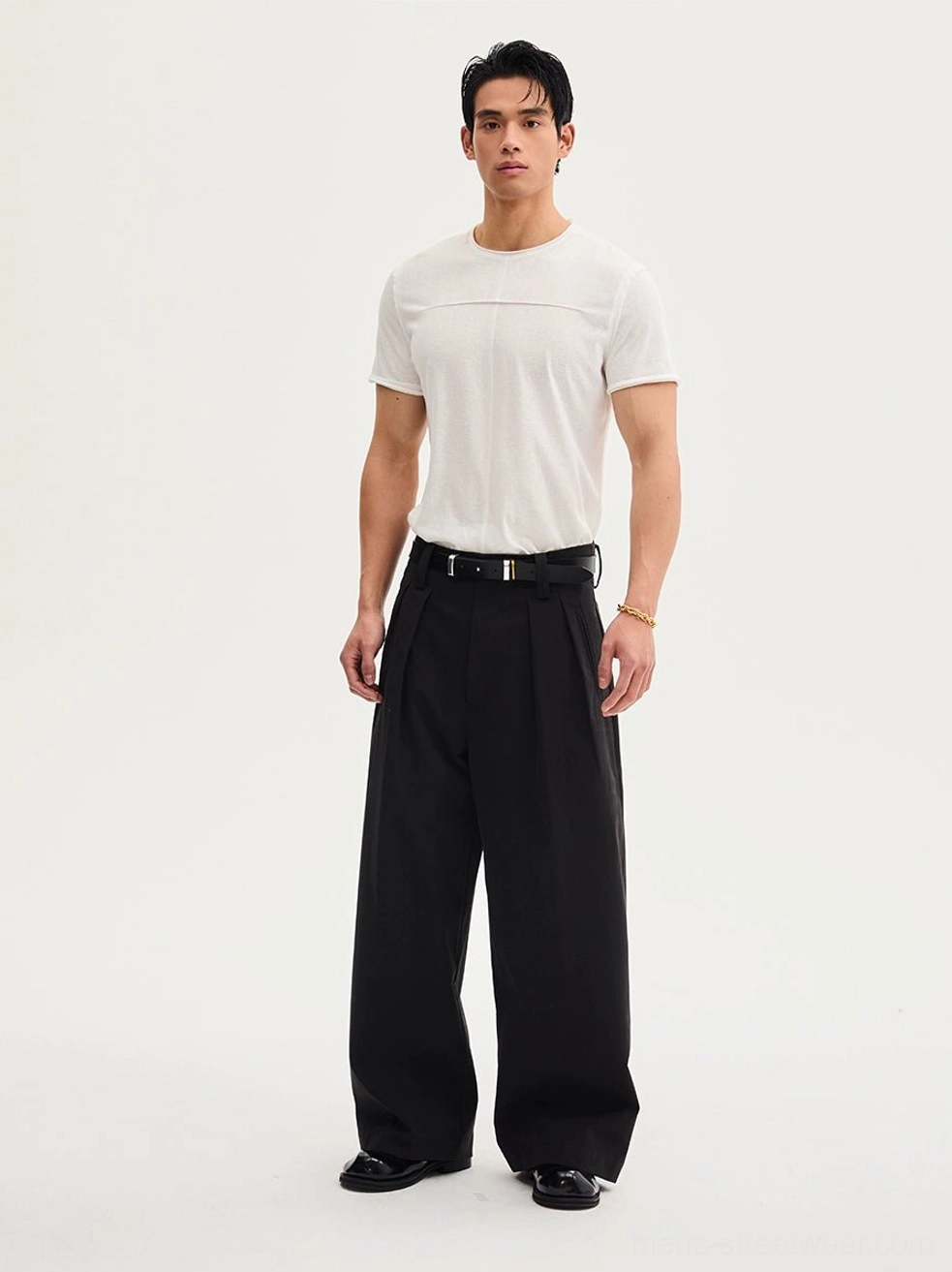 Front view of black high-waisted wide-leg streetwear trousers with front pleats, white T-shirt, black belt, and leather dress shoes