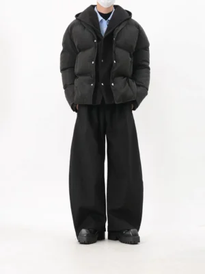 Black hooded snap-button puffer jacket with cropped relaxed silhouette styled with wide-leg black pants