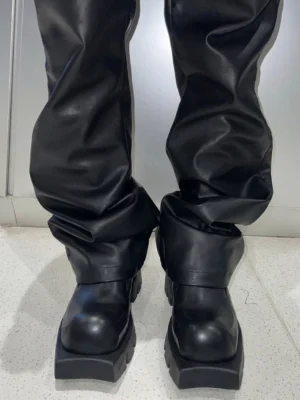 Black leather platform derby shoes styled with fitted black leather trousers in a dark contemporary streetwear outfit