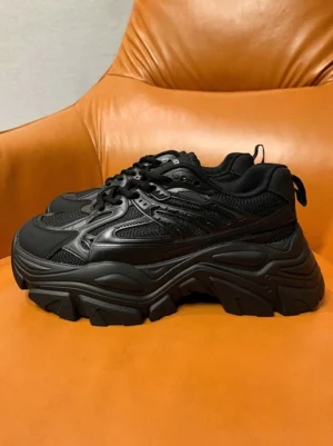 Black hyper-stack platform sneakers with breathable mesh vamp layered panels and chunky rugged sole front three-quarter view