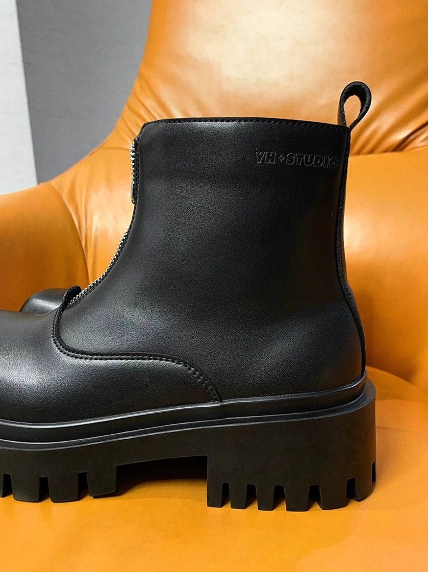 Black industrial platform boots featuring a sharp square toe, raised heel, smooth upper, and full-length front zipper