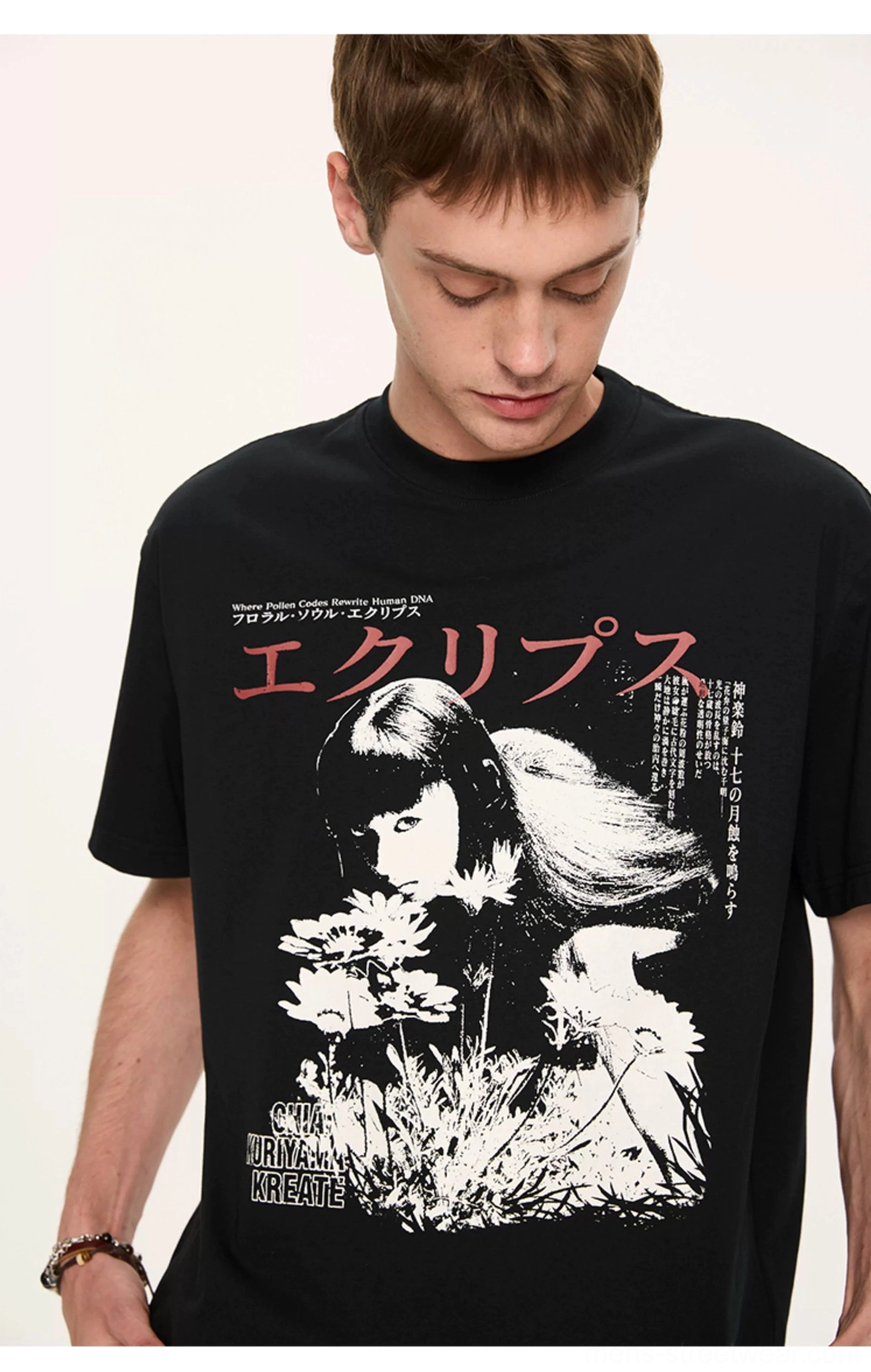 Close-up black Japanese graphic T-shirt showing detailed anime portrait artwork, floral elements, and supplementary text