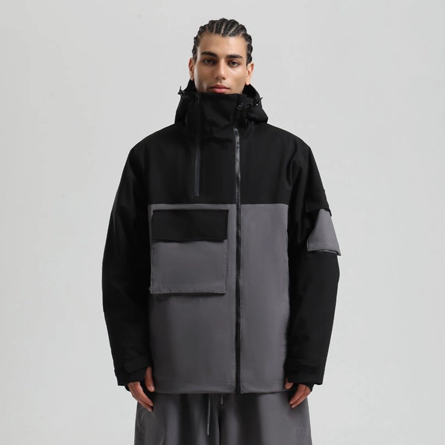 Black khaki and dark grey tri color ski jacket with hood, front flap pockets, sleeve patch pocket, and thumbhole cuffs