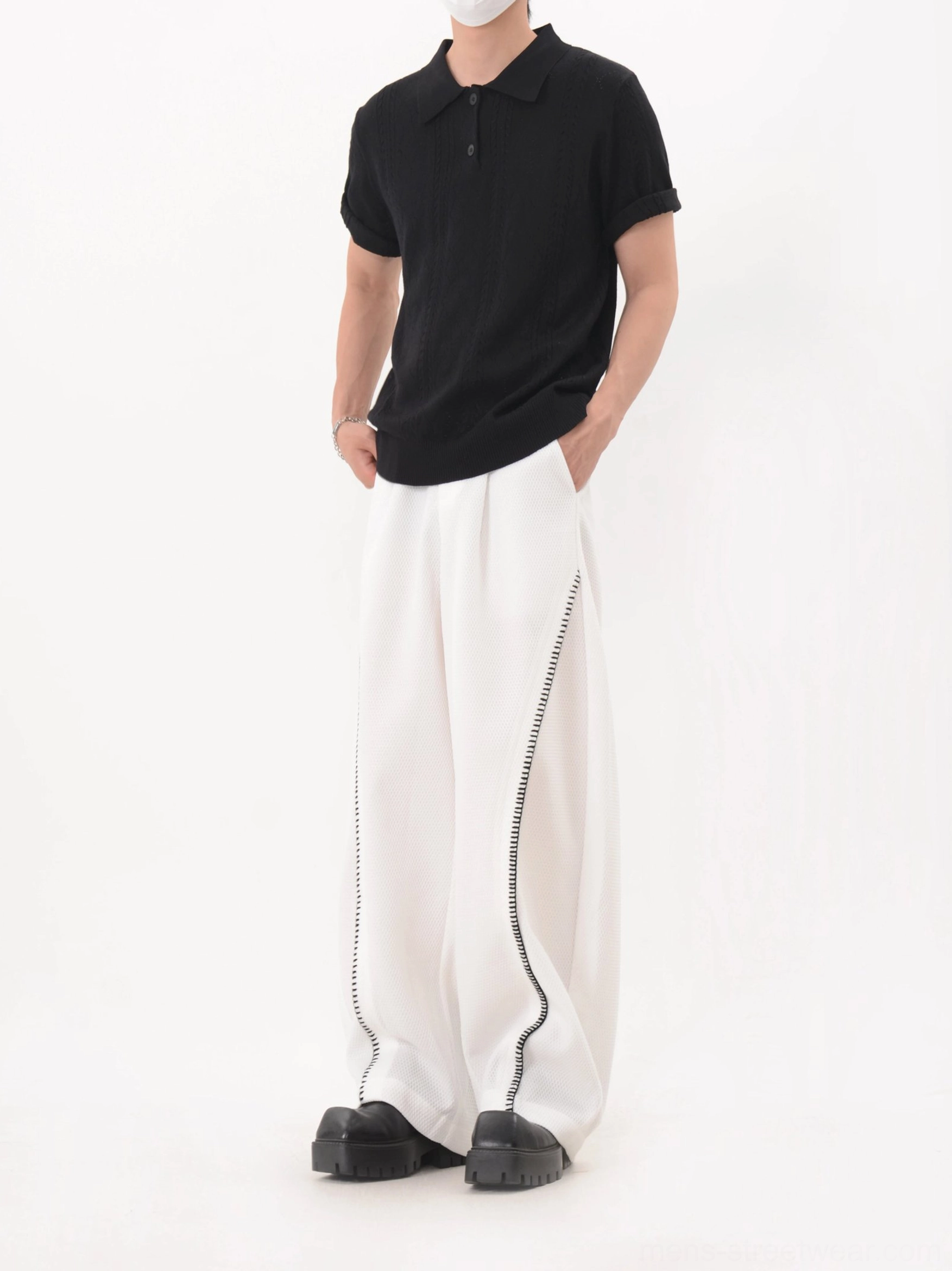 Black knit polo shirt with rolled cuffs and classic button collar in relaxed Korean inspired streetwear styling