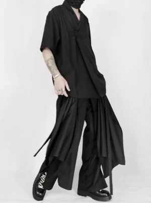 Side view of black Korean streetwear wide-leg trousers with flowing draped panels and long hanging side straps