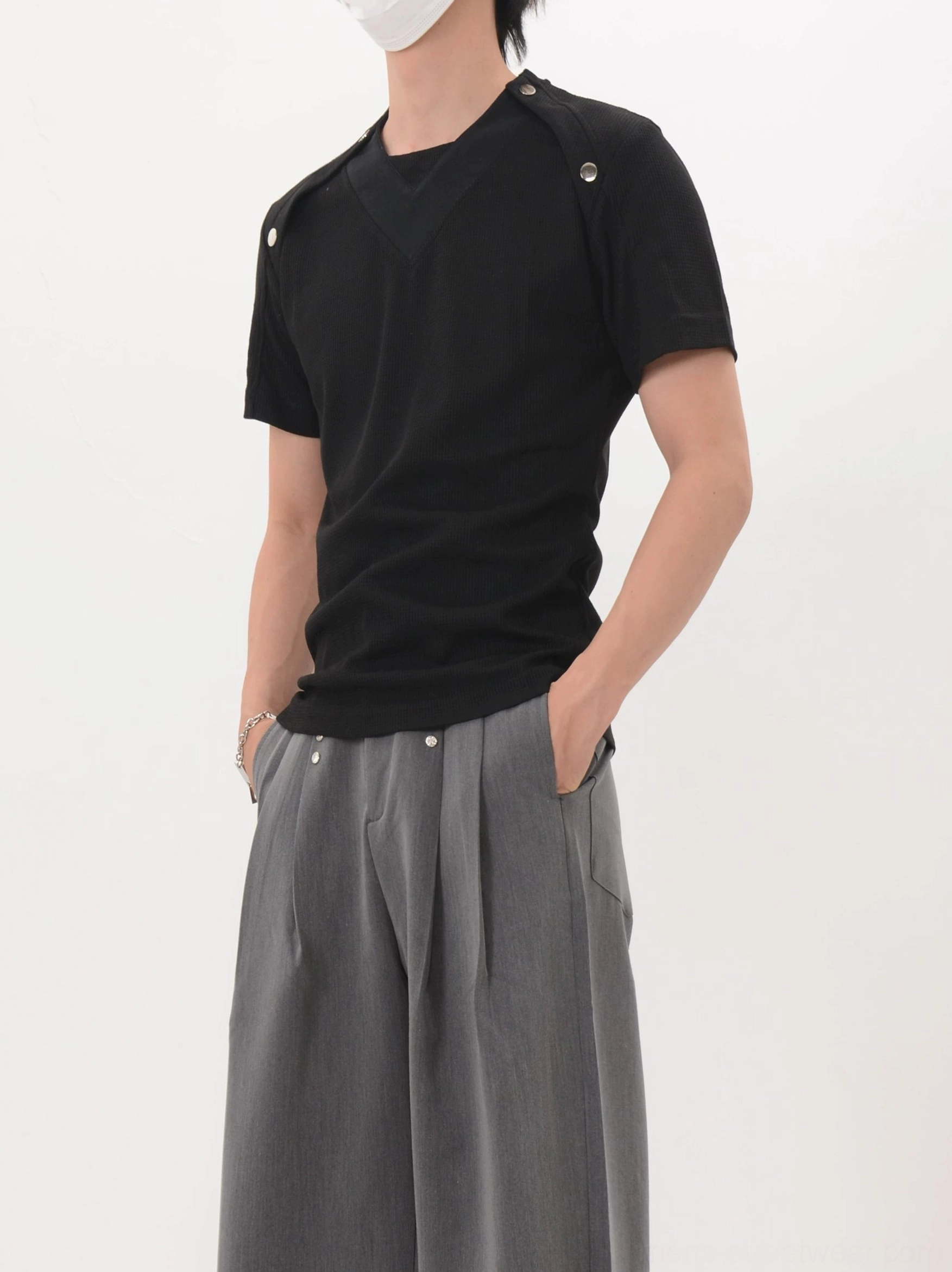 Black Korean streetwear shoulder snap tee photographed from a low left front angle with slim knit fit and industrial shoulder details