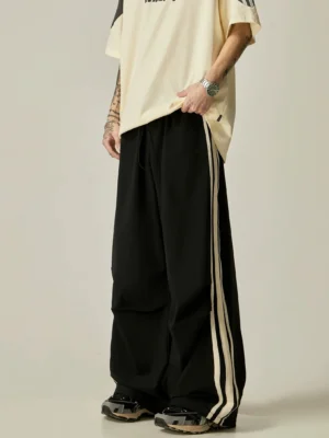 Black Korean streetwear wide-leg triple stripe athletic pants styled with an oversized beige t-shirt and retro sneakers
