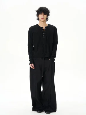 Black lace-up Henley streetwear shirt styled with wide-leg black trousers, metal eyelets, relaxed sleeves, and tailored chest seams