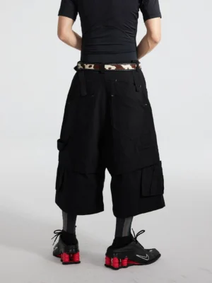 Black oversized cargo culottes back three-quarter view showing layered construction, rear utility pockets, and wide cropped fit