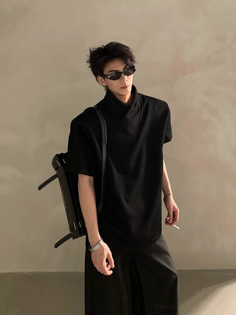 Black layered high-collar short-sleeve streetwear shirt on male model with sunglasses and shoulder bag in minimalist studio setting