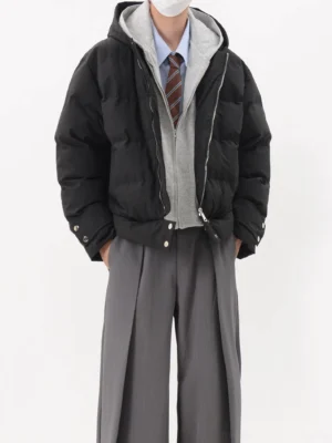 Black layered hooded oversized puffer jacket front view with padded cropped silhouette and silver snap cuff details