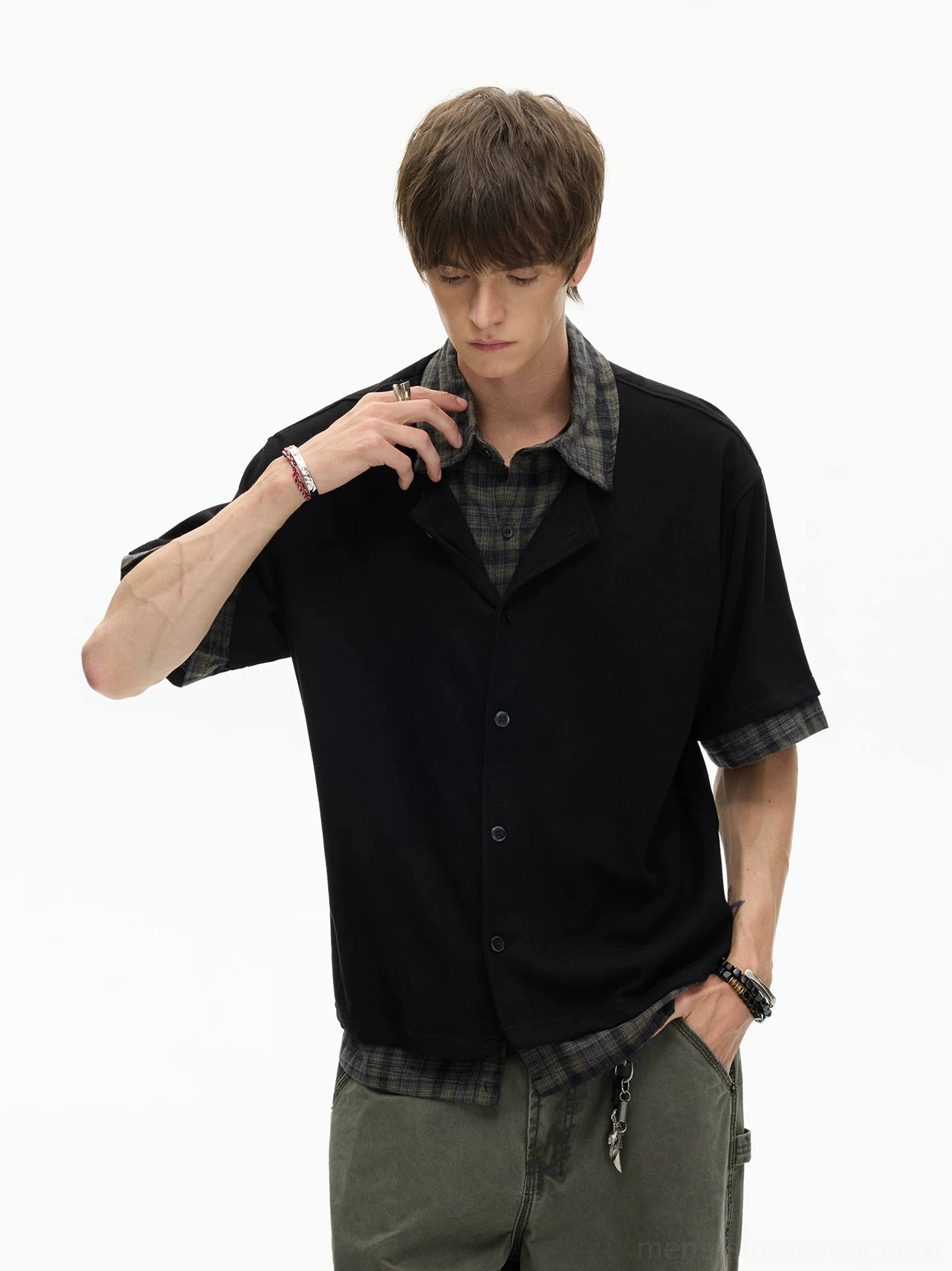 Side view of black layered plaid hem knit shirt showing relaxed short-sleeve Korean streetwear silhouette