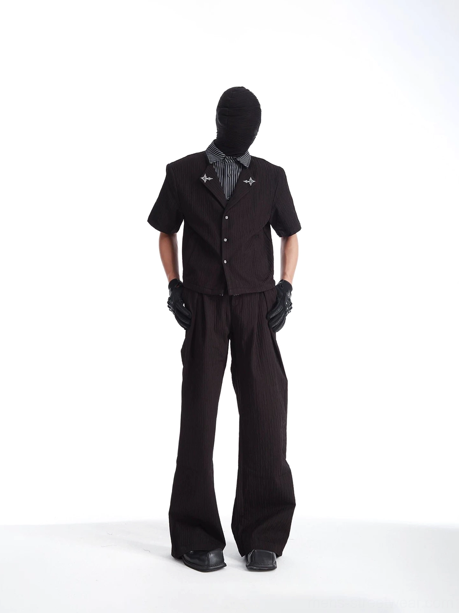 Black layered streetwear suit with textured short-sleeve shirt high-waisted wide-leg pants and monochrome styling