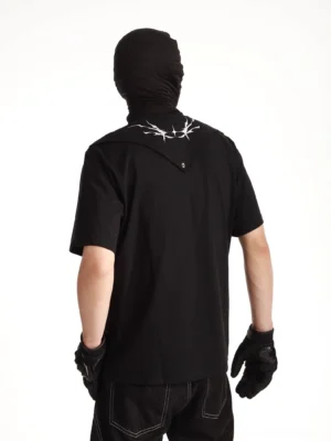 Black layered streetwear t-shirt rear view showing white thorn embroidery and decorative back snap panel