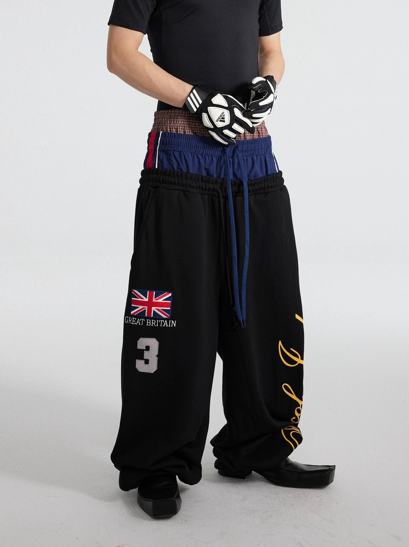 Black layered triple waist wide leg fleece track pants with graphic print and long drawstrings front outfit detail