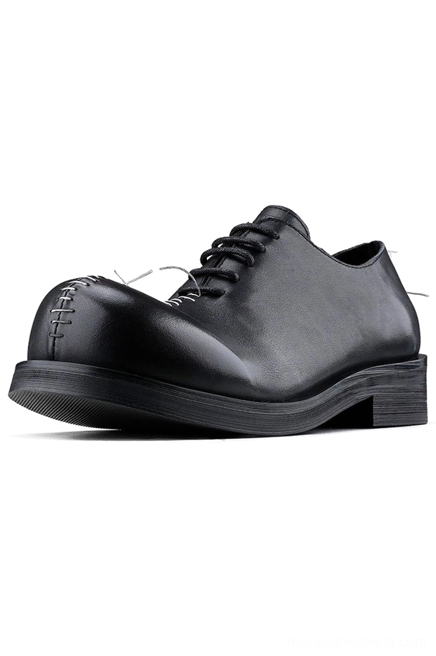 Black leather contrast stitch Oxford shoes in three-quarter side view with rounded toe, lace-up closure, white toe stitching, and rubber sole