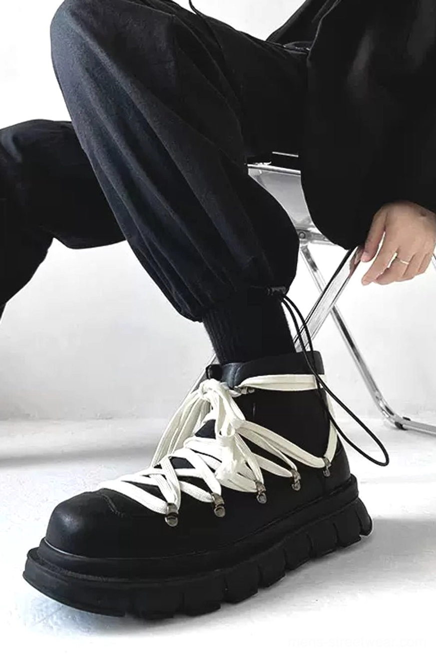 Outer side profile of black leather platform combat boot with off-white laces and chunky treaded sole on foot