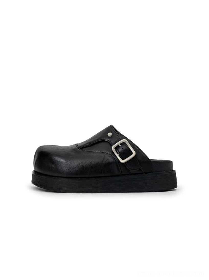 Side profile of a black leather platform mule showing natural leather grain rounded toe open heel and thick wear-resistant rubber outsole