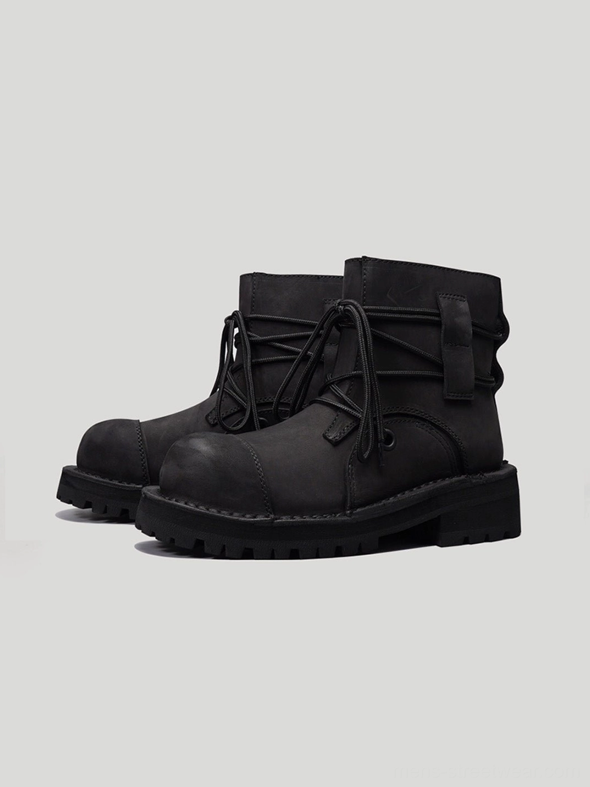 Pair of black leather utility ankle boots front three-quarter view with wraparound lacing and thick lug soles