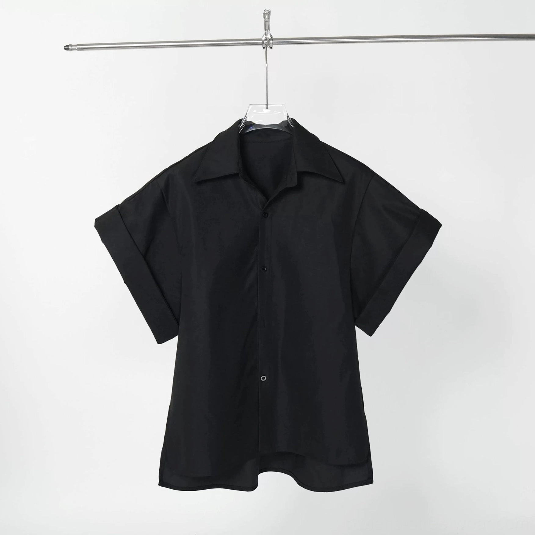 Flat front view of a black loose oversized short sleeve button down shirt jacket with notched collar and relaxed drape