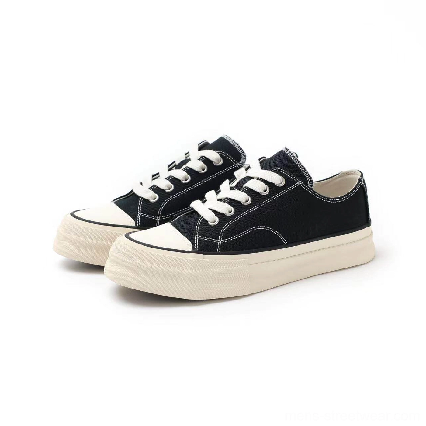 Pair of black low-top canvas platform sneakers with contrast stitching and off-white vulcanized soles