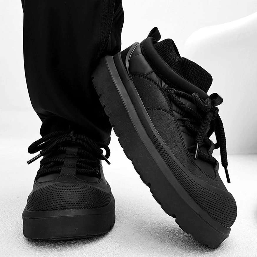 Black low top chunky platform winter boots with padded collar lace-up closure and thick rubber sole on white background