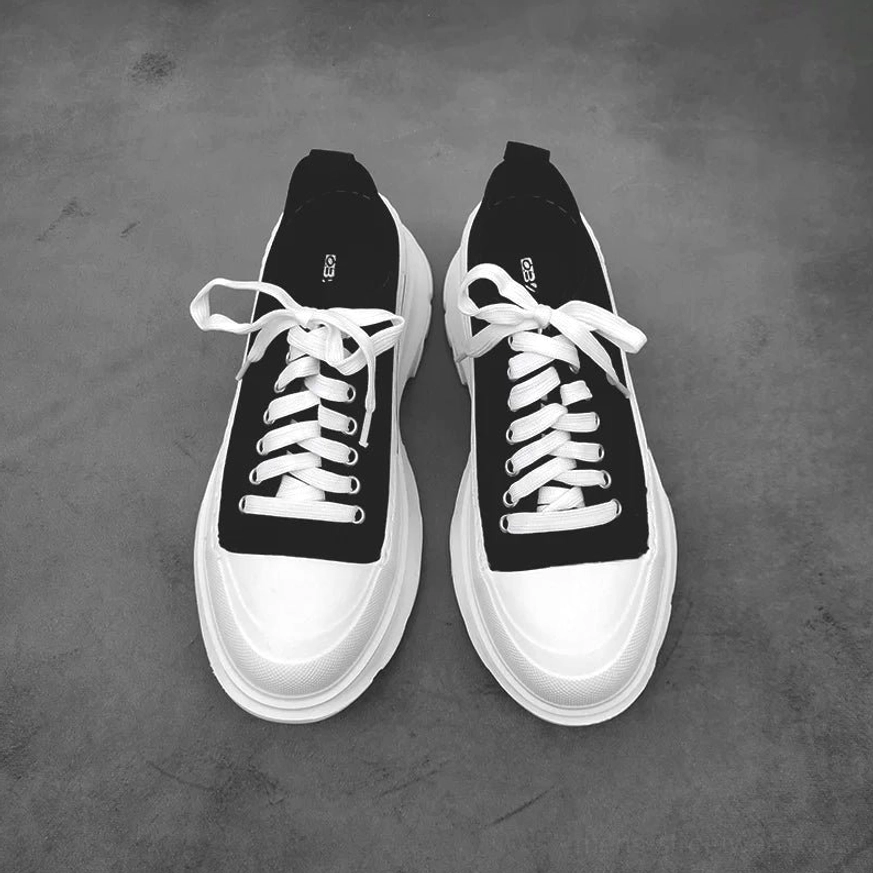 Black low-top platform canvas sneaker flat lay with white laces rubber toe cap heel pull tab and thick outsole